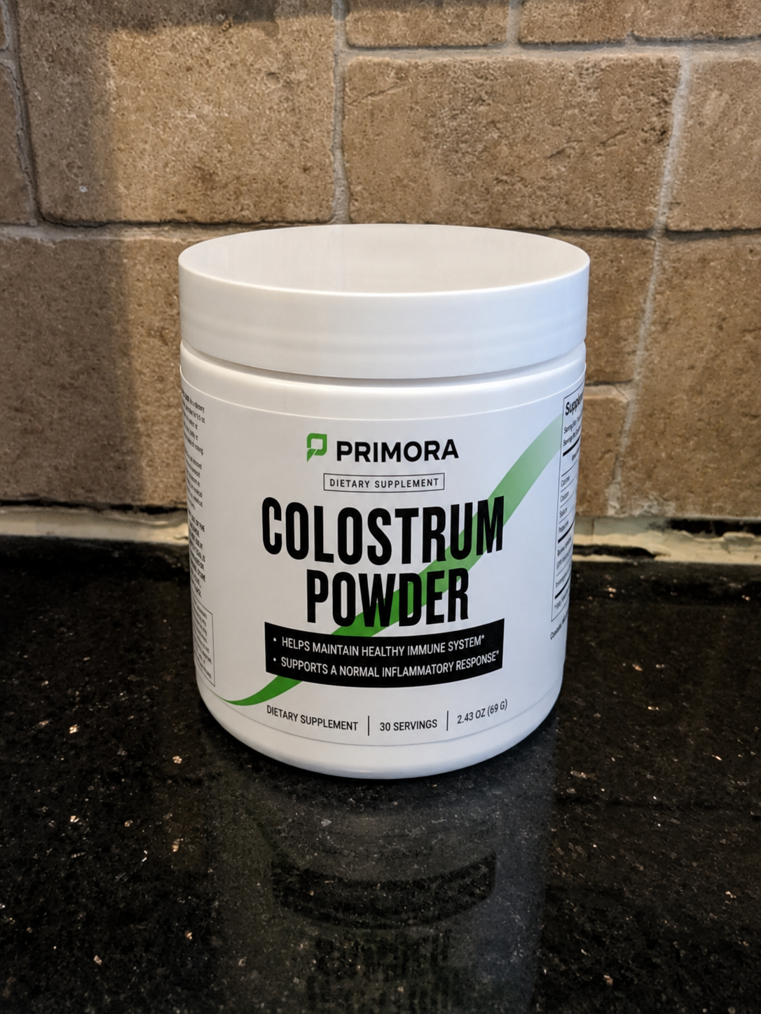 Primora Colostrum Powder tub on kitchen counter