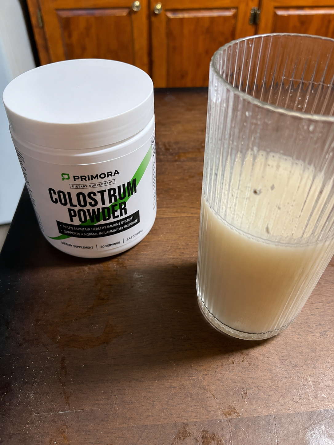 Primora Colostrum Powder mixed in a glass
